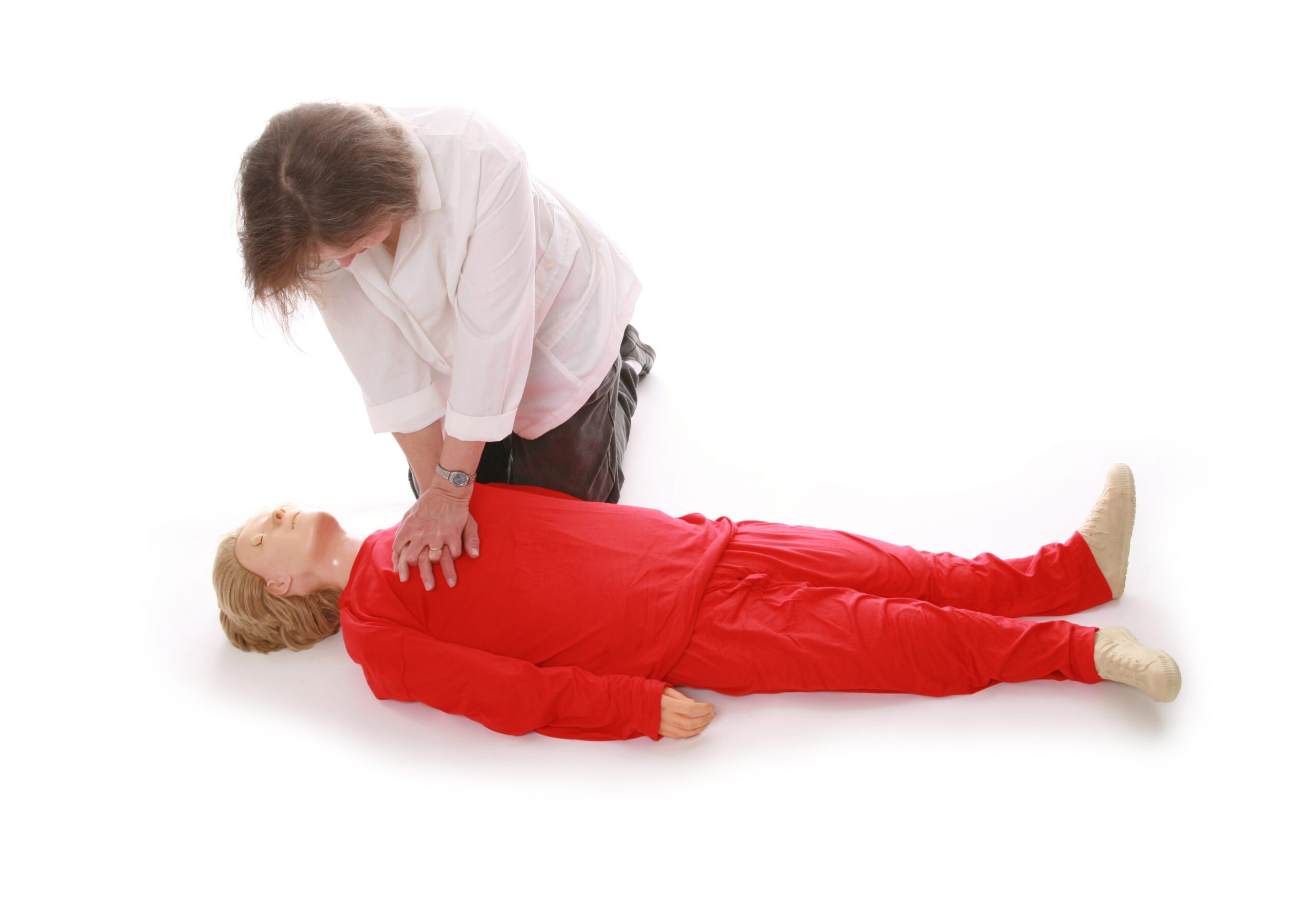 A woman performing chest compressions on a mannequin